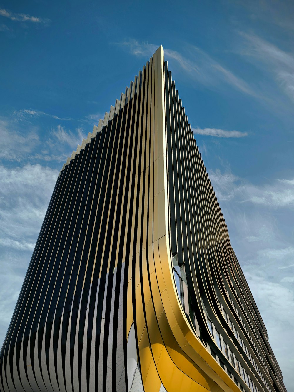 a very tall building with a yellow curved design