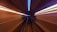A tunnel is depicted from the perspective of a fast-moving vehicle, creating a sense of motion through blurred lines and a vanishing point. Bright streaks of light in blue and orange run along the sides, enhancing the sensation of speed.