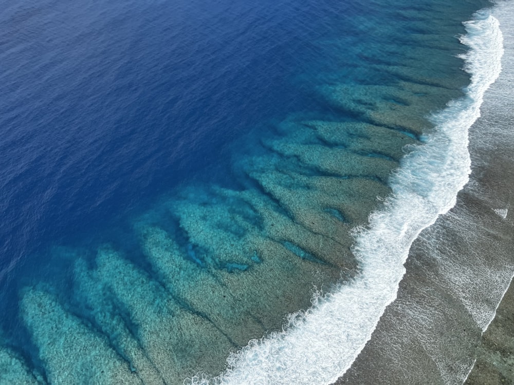 an aerial view of a beach with blue water