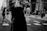 Black and white candid street photo of a bustling urban crosswalk with blurred motion.