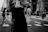 Black and white candid street photo of a bustling urban crosswalk with blurred motion.