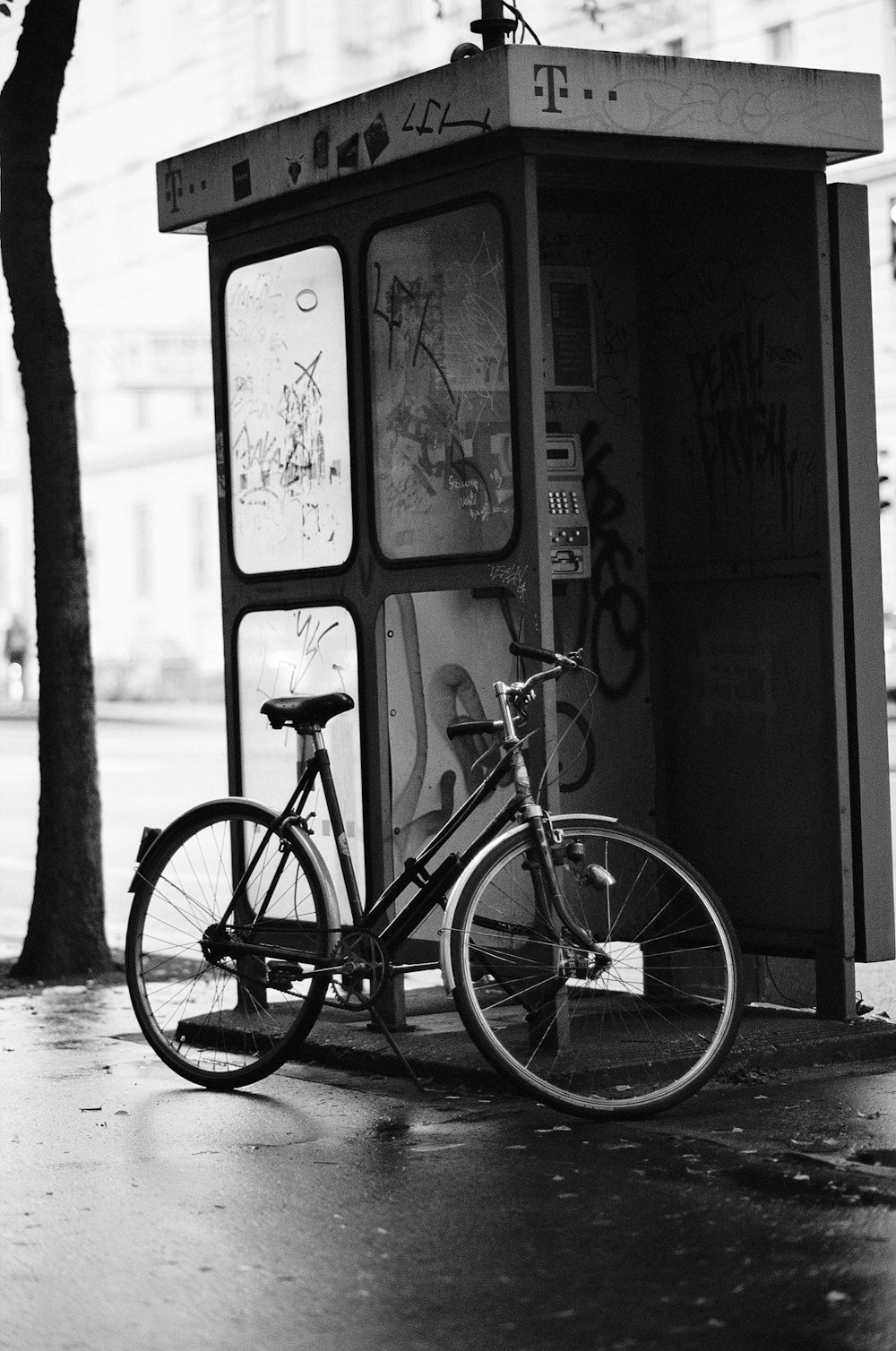 a bicycle parked next to a phone booth