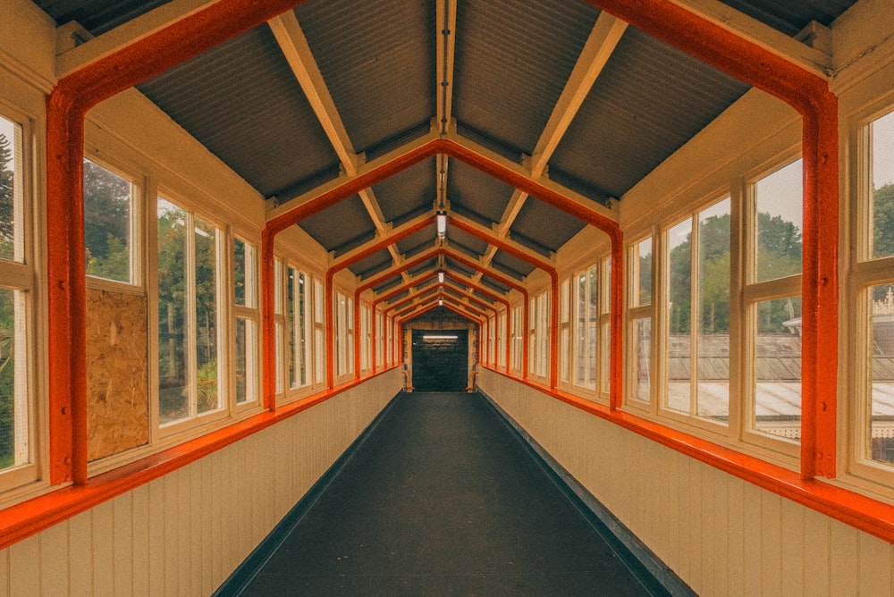 a long hallway with orange trim and windows