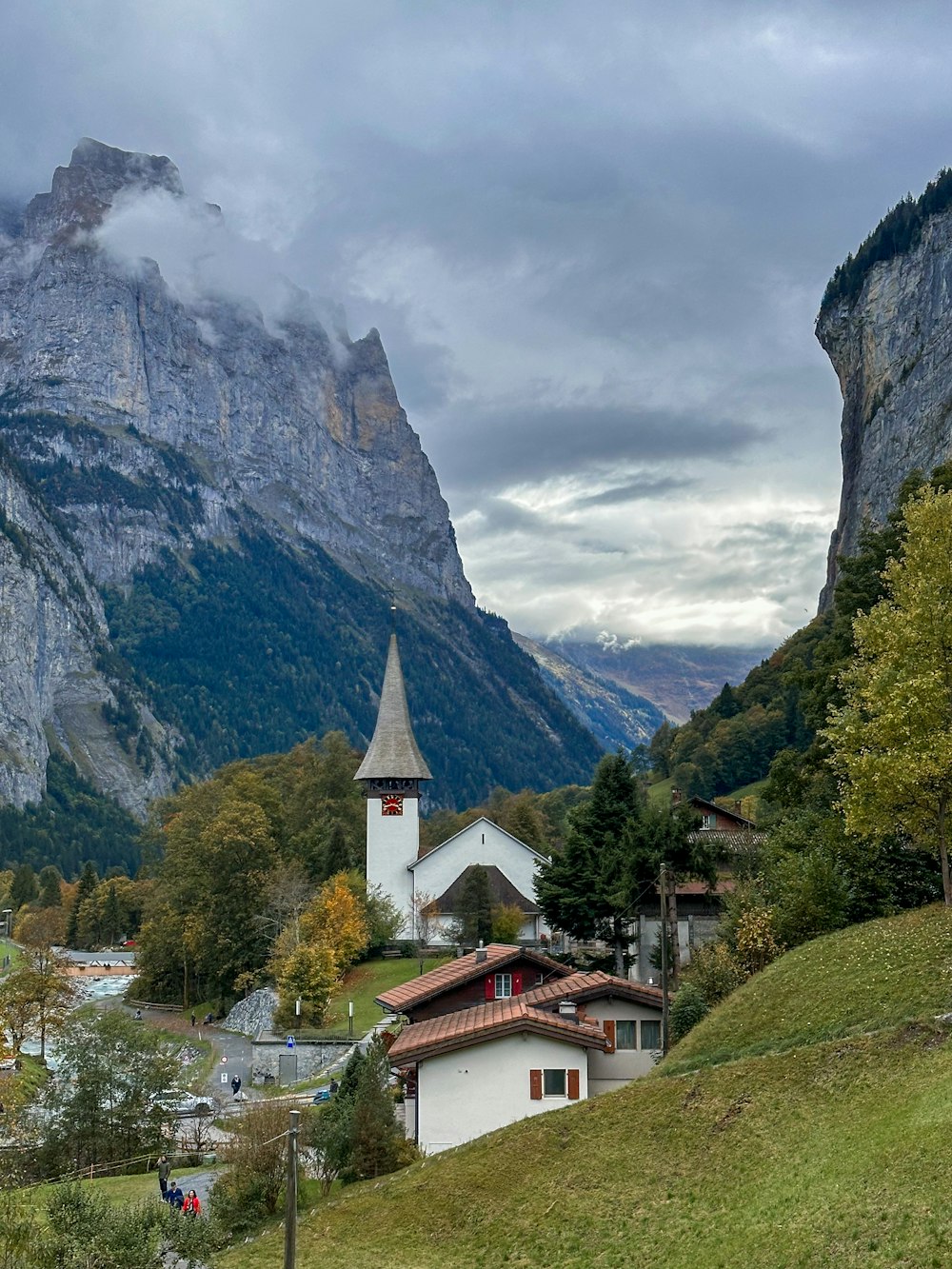 a church in a valley with mountains in the background