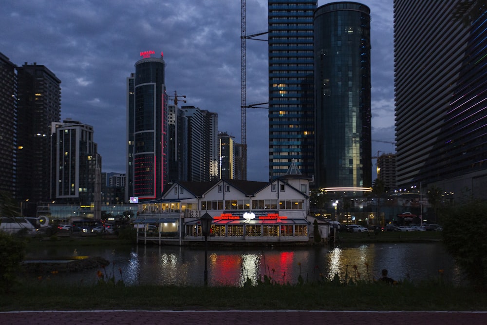 a city skyline with tall buildings and a river in the foreground