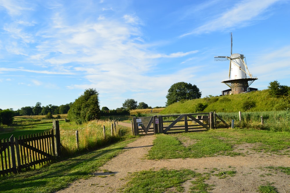 a windmill on top of a hill near a fence