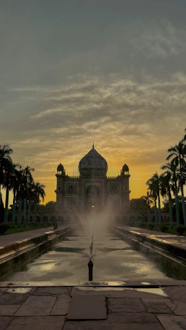 A vibrant sunset over the historic Deeg Palace gardens, with blooming flowers and ancient stone pathways.