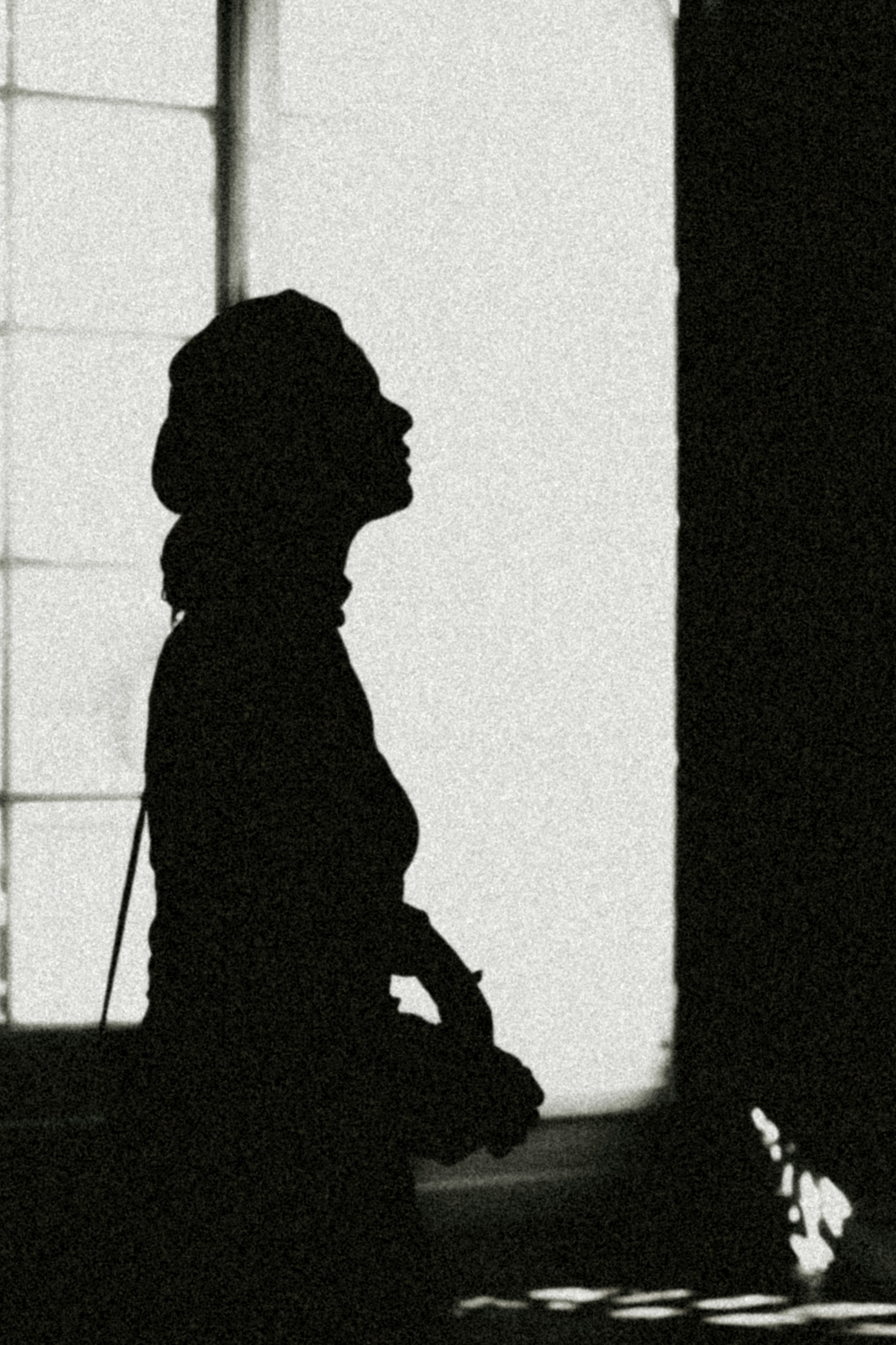 die Silhouette einer Person, die vor einem Fenster steht