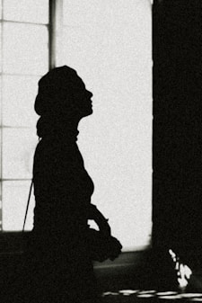 a silhouette of a person standing in front of a window