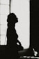 a silhouette of a person standing in front of a window
