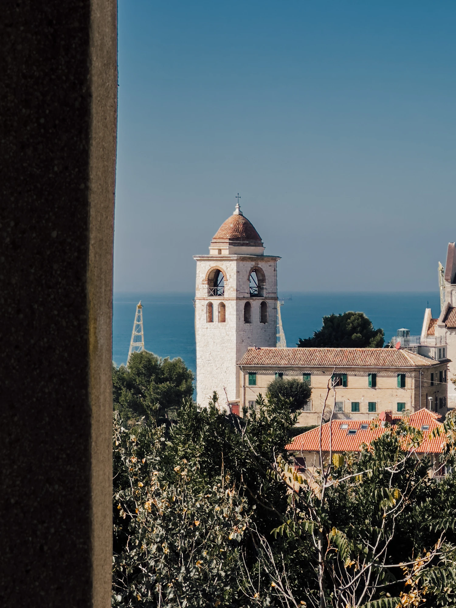 The bell tower of Ancona cathedral above terracotta roofs and the Adriatic