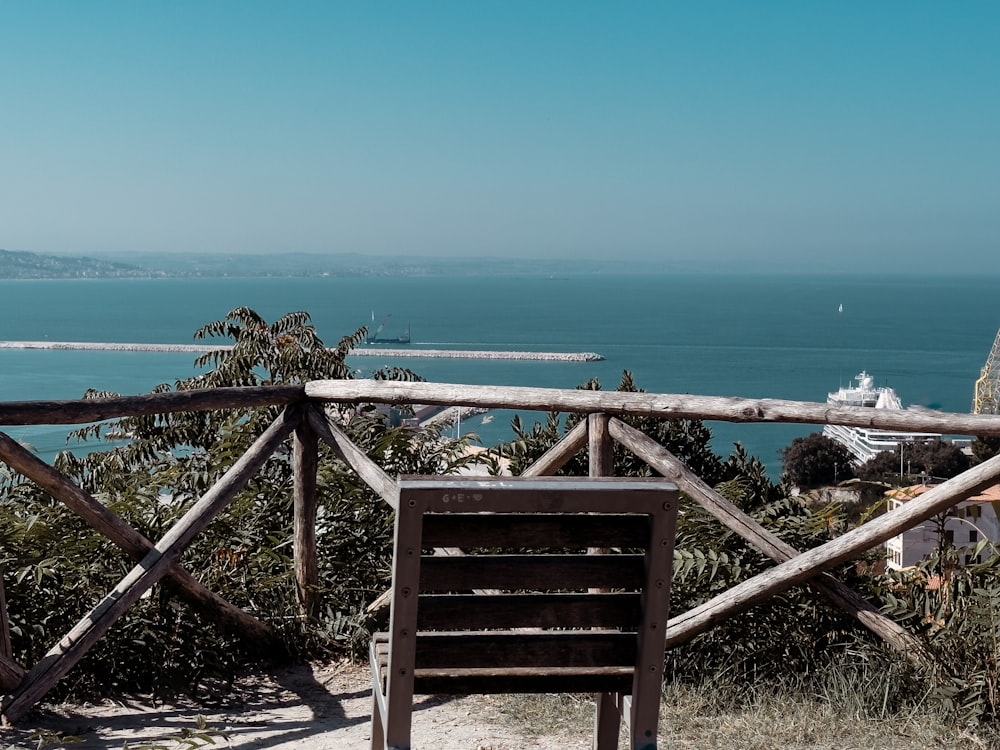 a wooden bench sitting on top of a hill next to the ocean