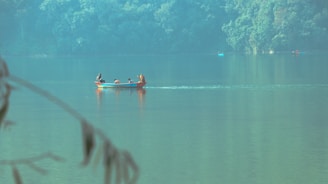 a group of people in a small boat on a lake