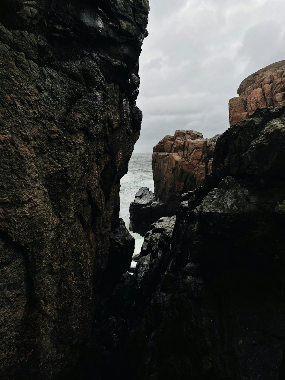 a person standing on top of a cliff next to the ocean