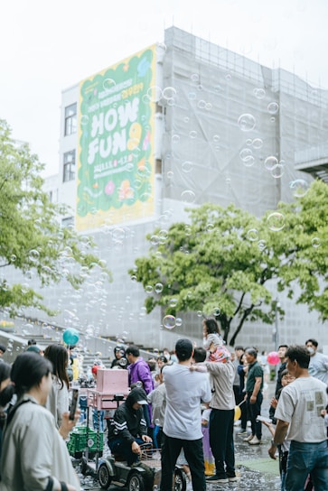 Children and adults enjoying a lively outdoor event with foam cannon and popcorn machine.