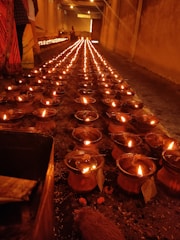 Devotees lighting oil lamps inside the temple during a serene pooja ceremony.