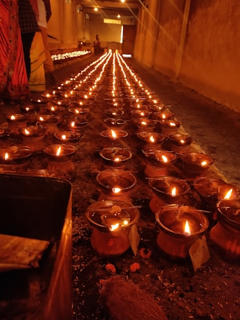Devotees lighting oil lamps by the temple’s inner sanctum during a serene evening.