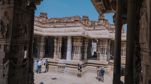 A group of travelers exploring an ornate Indian temple adorned with intricate carvings.