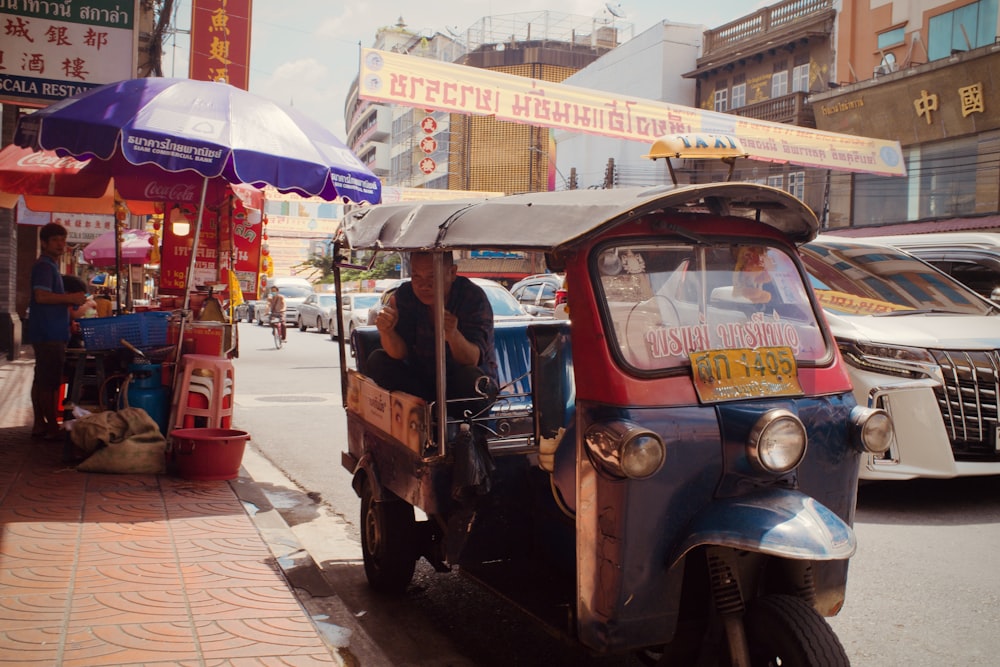 Um tuk tuk está estacionado na beira da estrada