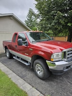 A fully replaced windshield on a pickup truck parked in a customer's driveway.