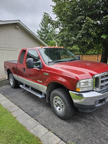 A pickup truck parked outside a home, ready for a scheduled junk removal pickup.