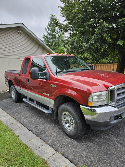 Our mobile detailing van parked beside a sparkling pickup truck in a rustic driveway