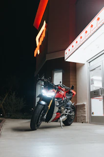 A delivery motorcycle parked outside a modern Riyadh building at sunset.