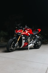 A sleek red petrol motorcycle parked on a city street in Kolkata.