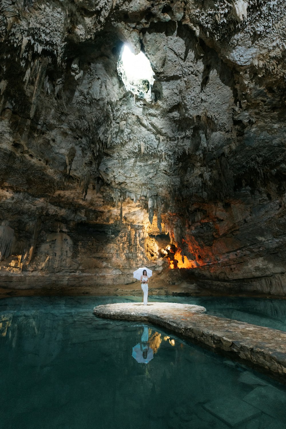 a person standing on a rock in a cave