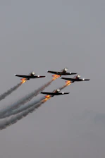Darkstar L39 Albatros cutting through dusk skies with smoky trails at a packed airshow.