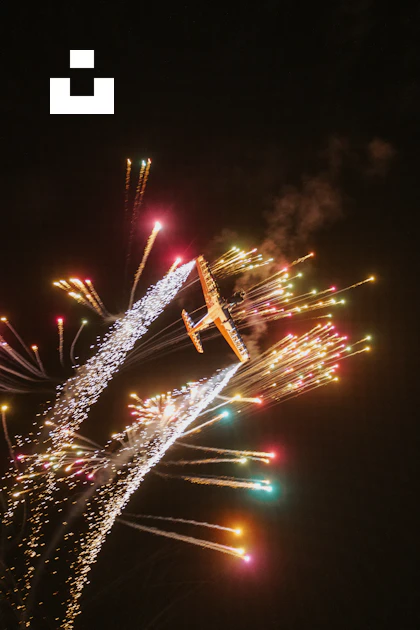 A plane is flying in the sky with a lot of fireworks photo – Free ...