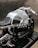A sleek, silver motorcycle showcasing a modern, metallic design with visible components and a black cushioned seat. The motorcycle features intricate engineering details and a sturdy frame, emphasizing its mechanical aesthetic.