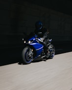 A sleek cyberpunk motorcycle with glowing blue accents speeding through a digital tunnel.