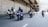 A group of motorcyclists riding together on a multi-lane road under an overpass. All riders are wearing helmets and protective gear. The scene appears to be urban with concrete structures and multiple lanes for traffic. Some cars can be seen in the background.