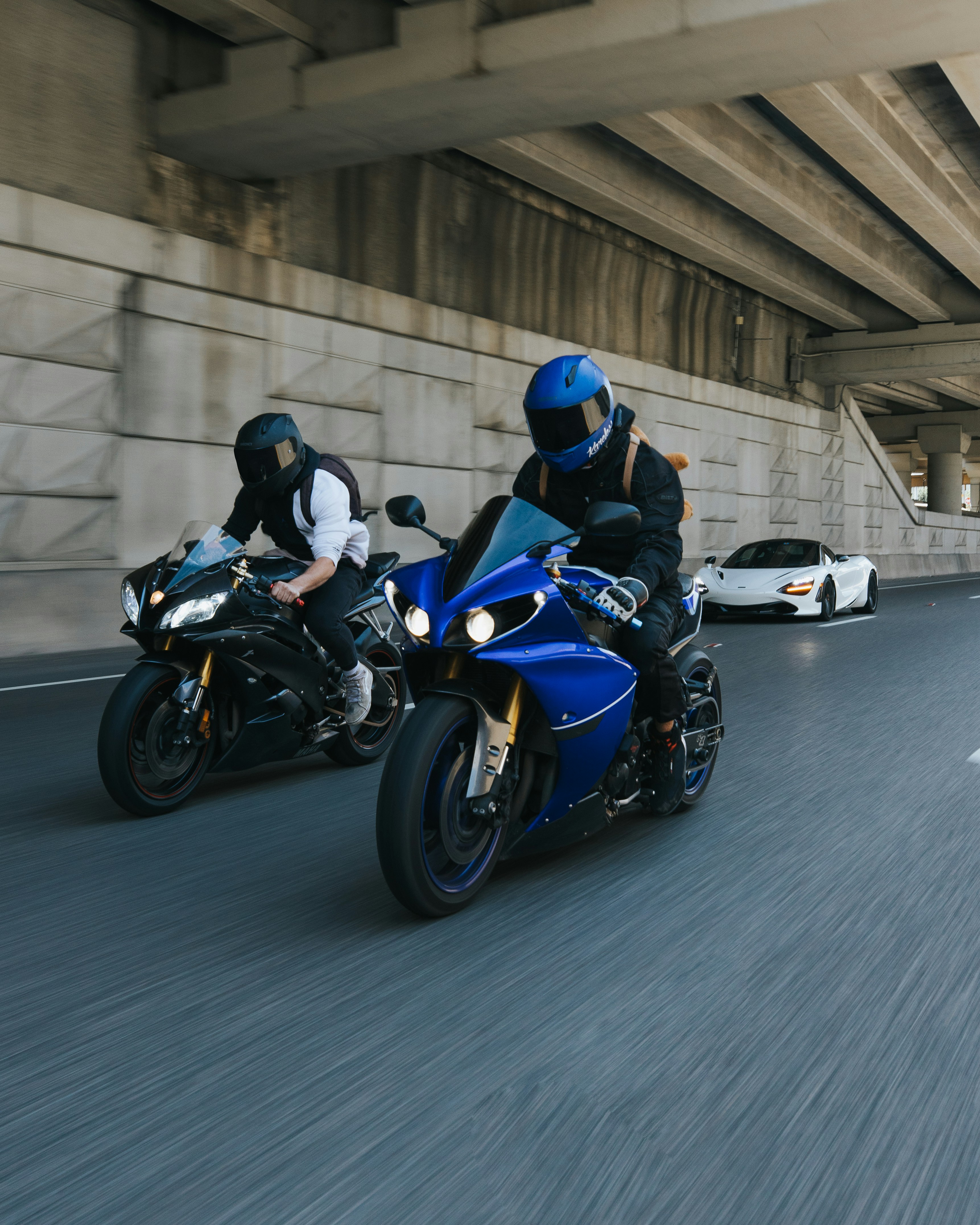 two people riding motorcycles on a city street