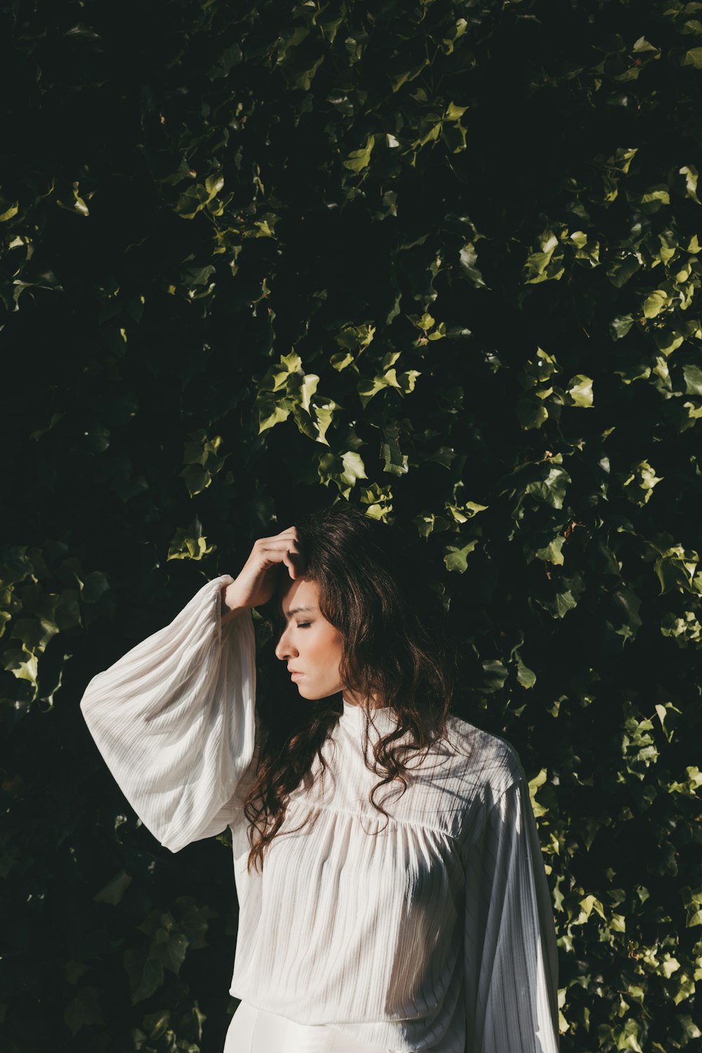 a woman standing in front of a tree