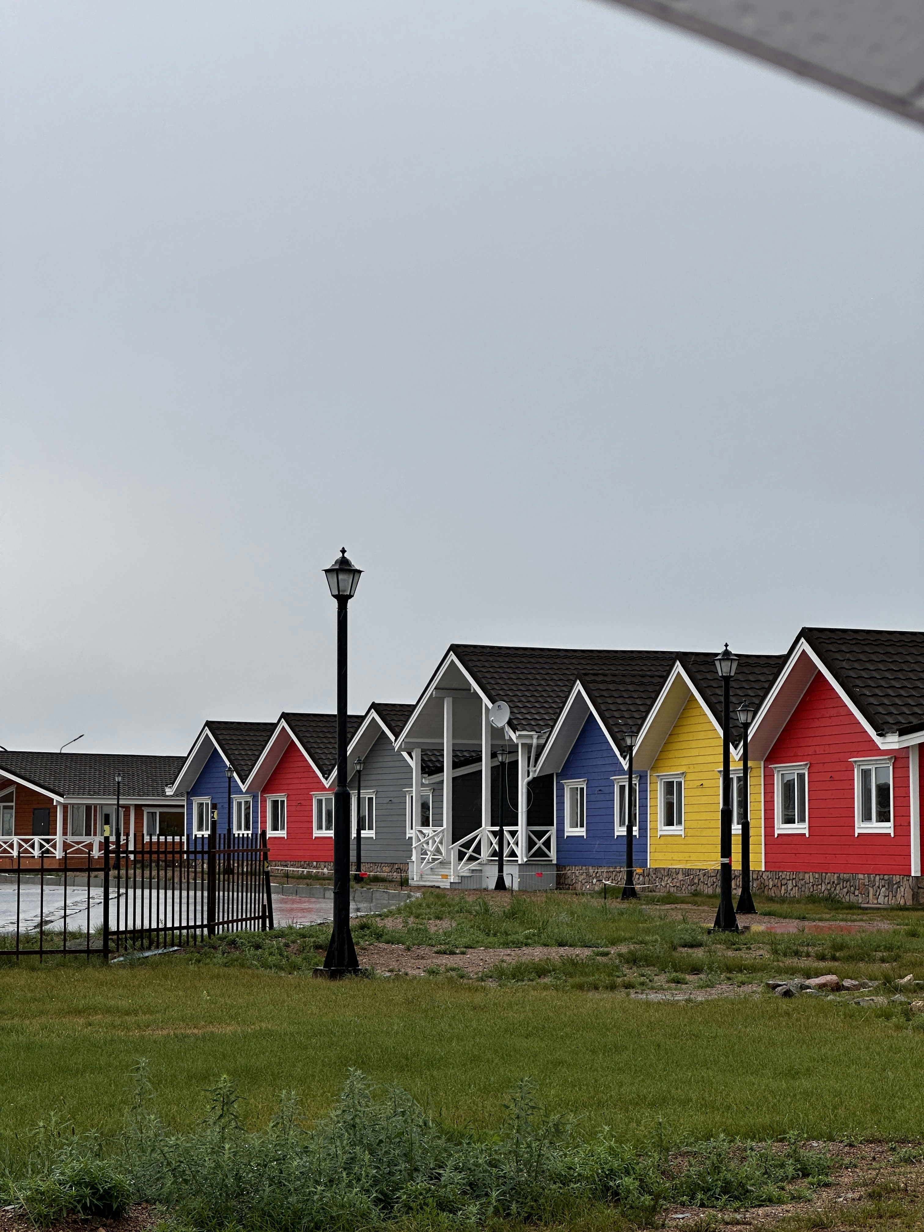 a row of colourful houses and green grass
