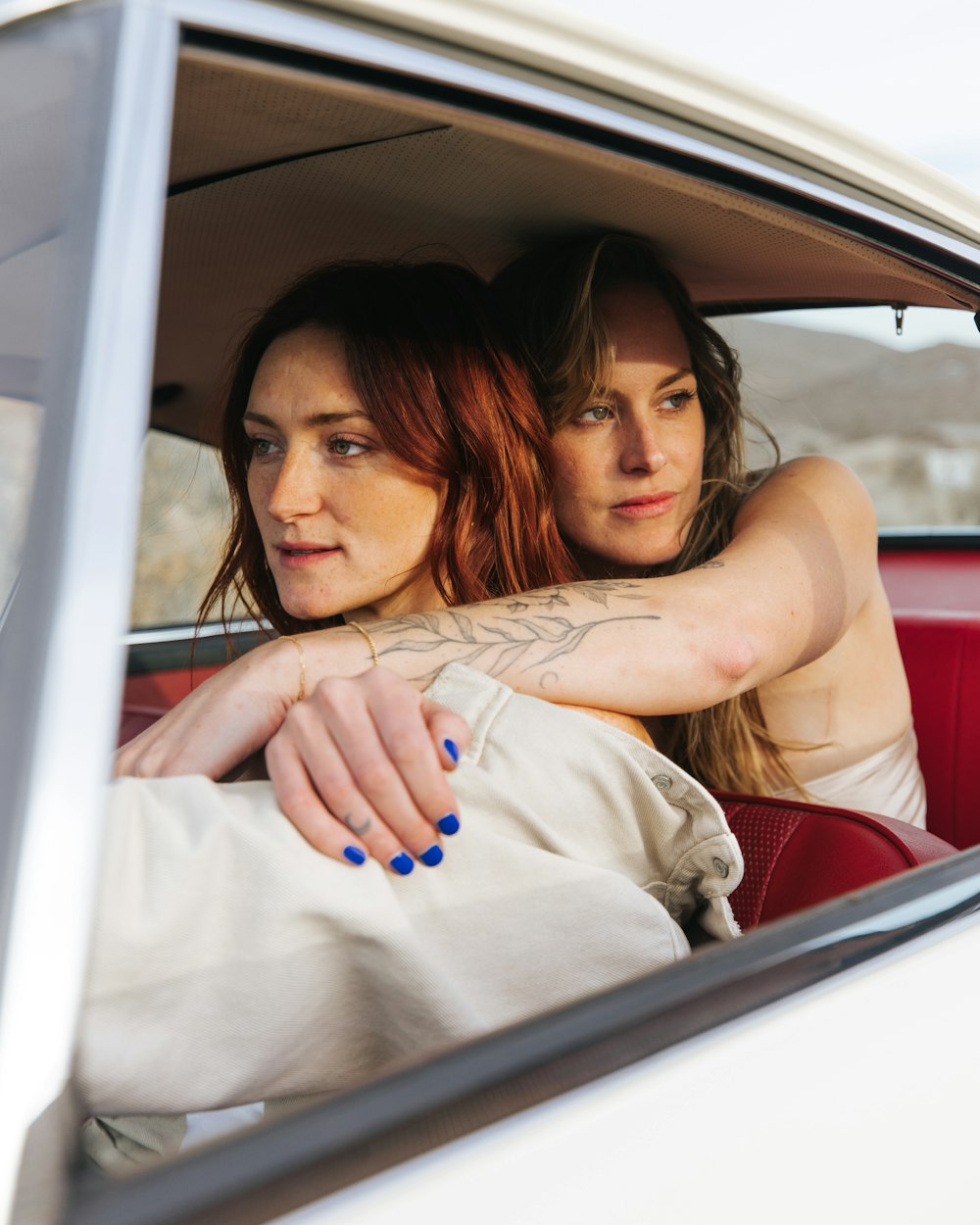 a couple of women sitting inside of a car
