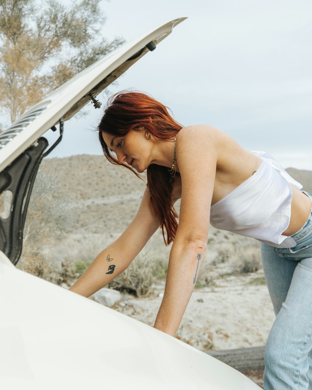 una donna appoggiata al cofano di un'auto