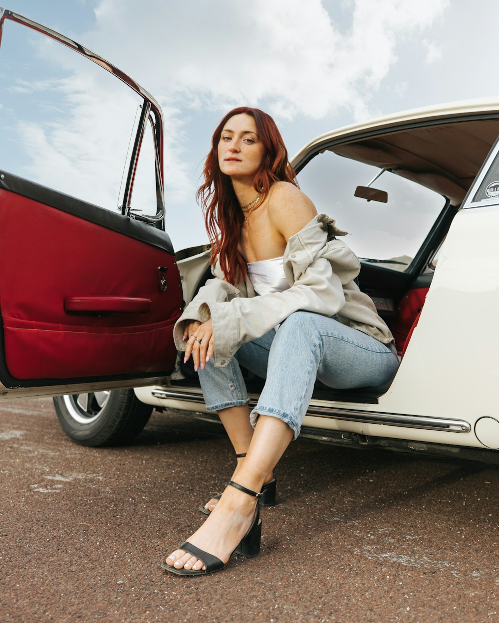 a woman sitting in the open door of a car