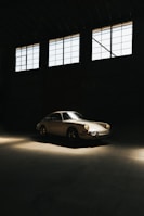A classic car parked in a sunlit garage.