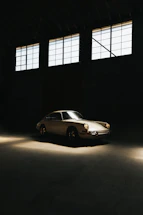 A sleek vintage car parked in a stylish Mallorca garage with warm golden lighting.