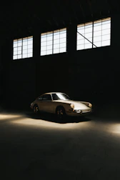 A sleek vintage car parked under soft natural light.