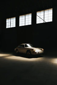 A vintage classic car gleaming under soft natural light in a cozy garage.