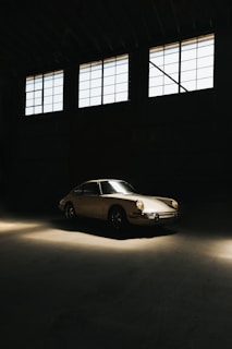 A classic vintage car restored to pristine condition, showcased under soft lighting