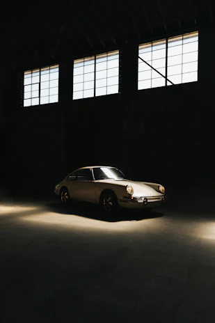 A restored classic car engine gleaming under soft lighting in a vintage garage setting.