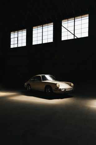 A classic car displayed in a sunlit garage, emphasizing its vintage appeal.