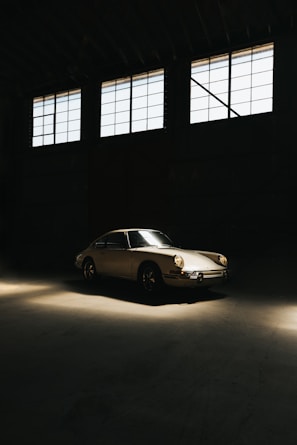 A classic car parked in a sunlit garage.