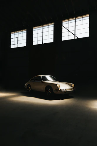 A restored classic car engine gleaming under soft lighting in a vintage garage setting.