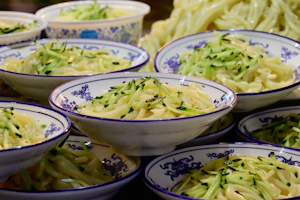 Assortment of colorful noodles and kwetiau displayed in rustic bowls.